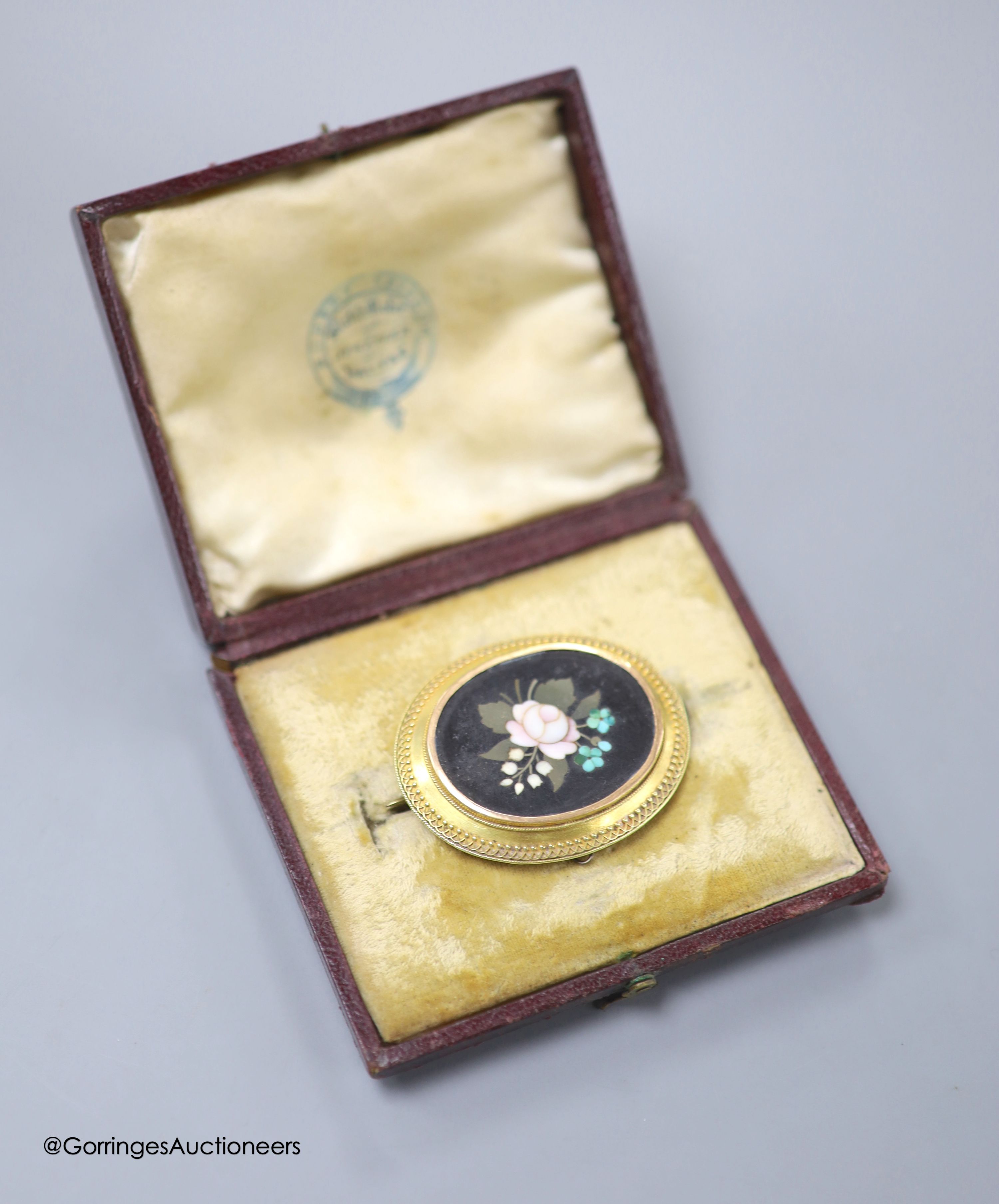 A cased Victorian yellow metal and pietra dura set oval brooch, with foliate motif, 45mm